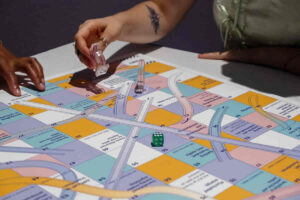 Board game with two players' hands moving pieces.